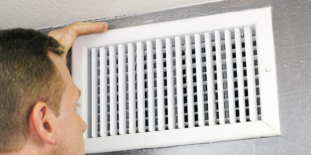 man inspecting an air duct for cleaning